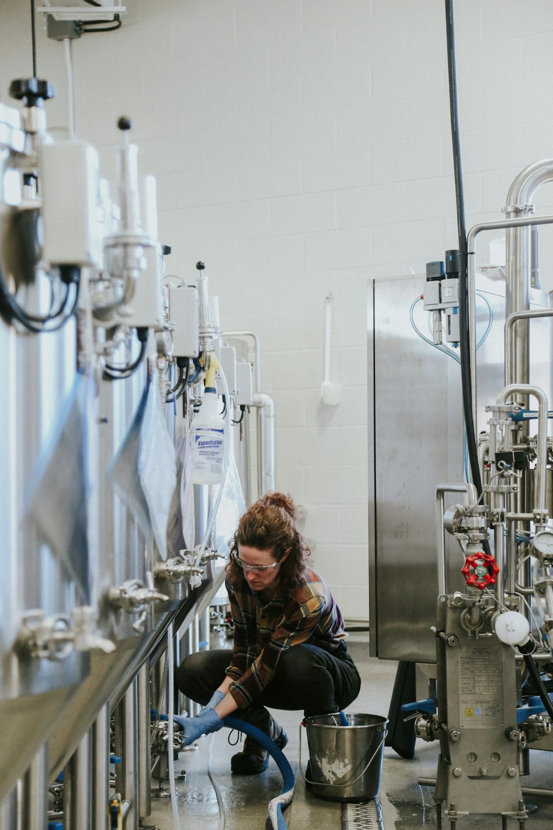 Sarah adjusts the valves of the hot water machine as she prepares for the next step in the brewing process.